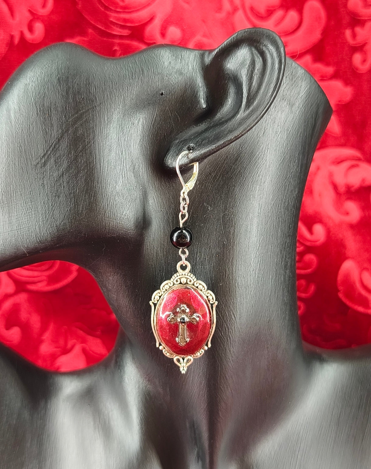 Boucles d’oreilles gothiques faites main avec médaillons rouges, croix argentées et perles noires portées