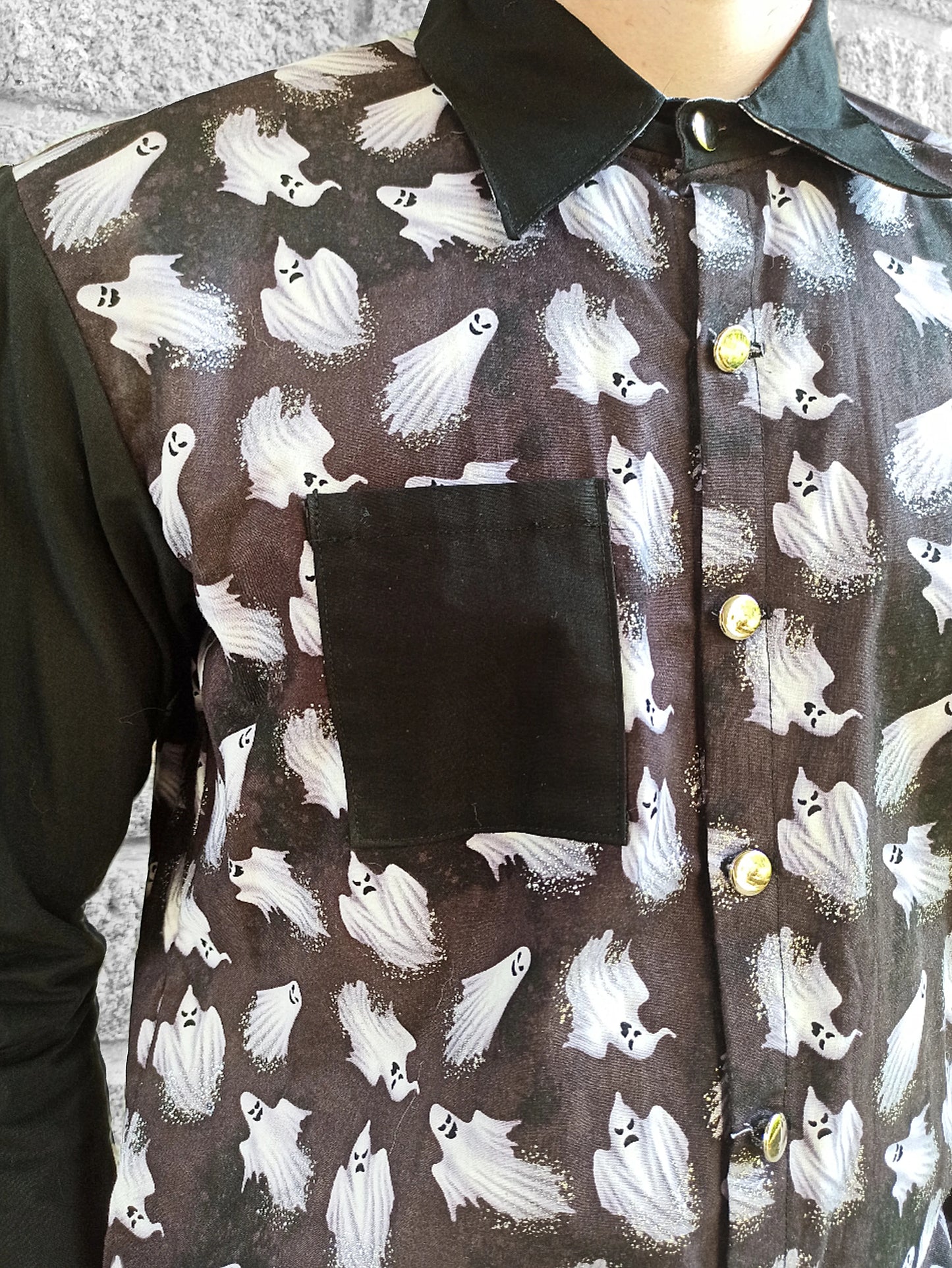 Boutons argentés sur chemise noire alternative
Zoom sur les paillettes fantômes et contraste tissu noir