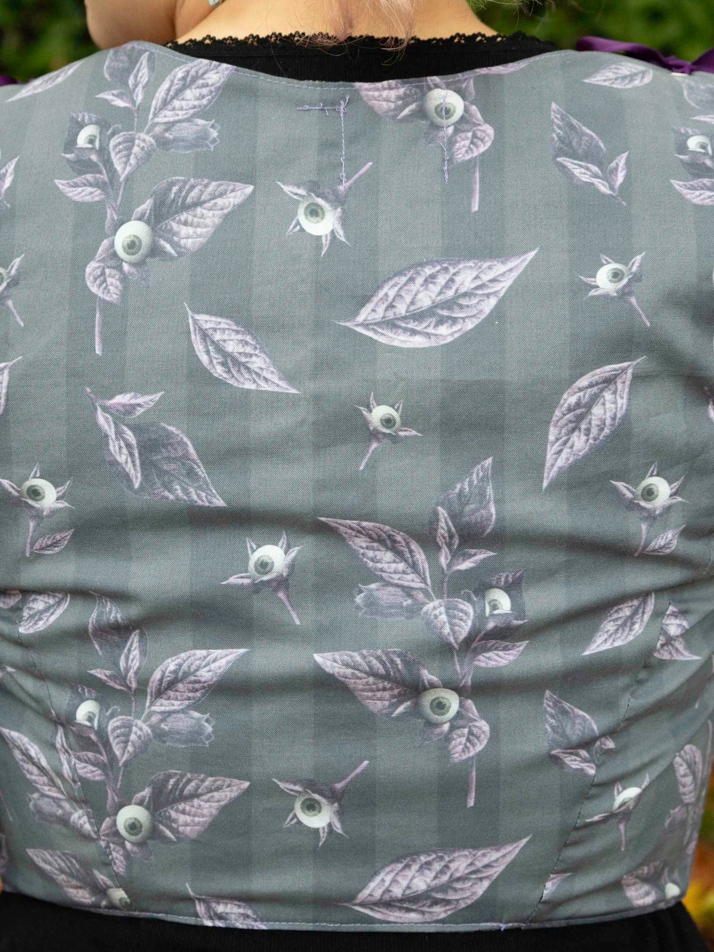 zoom sur les motifs oeils et feuilles du corset violet et gris