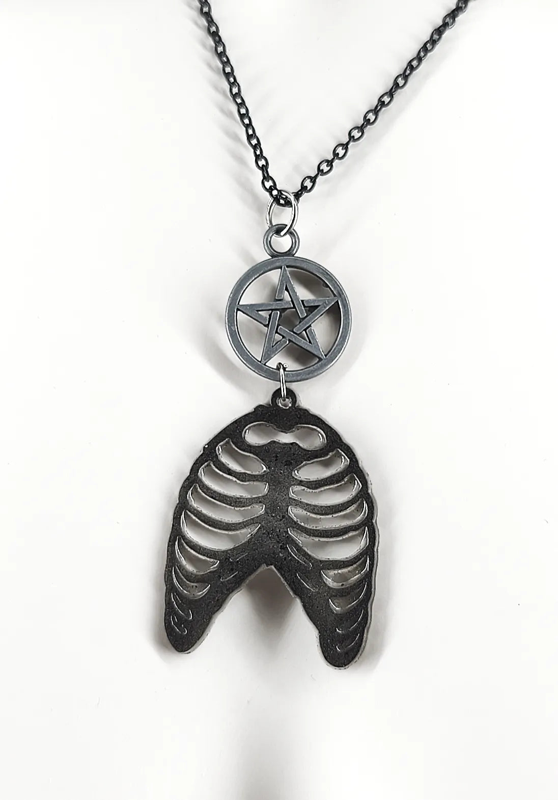 Détail du collier gothique noir en résine avec cage thoracique et pentacle