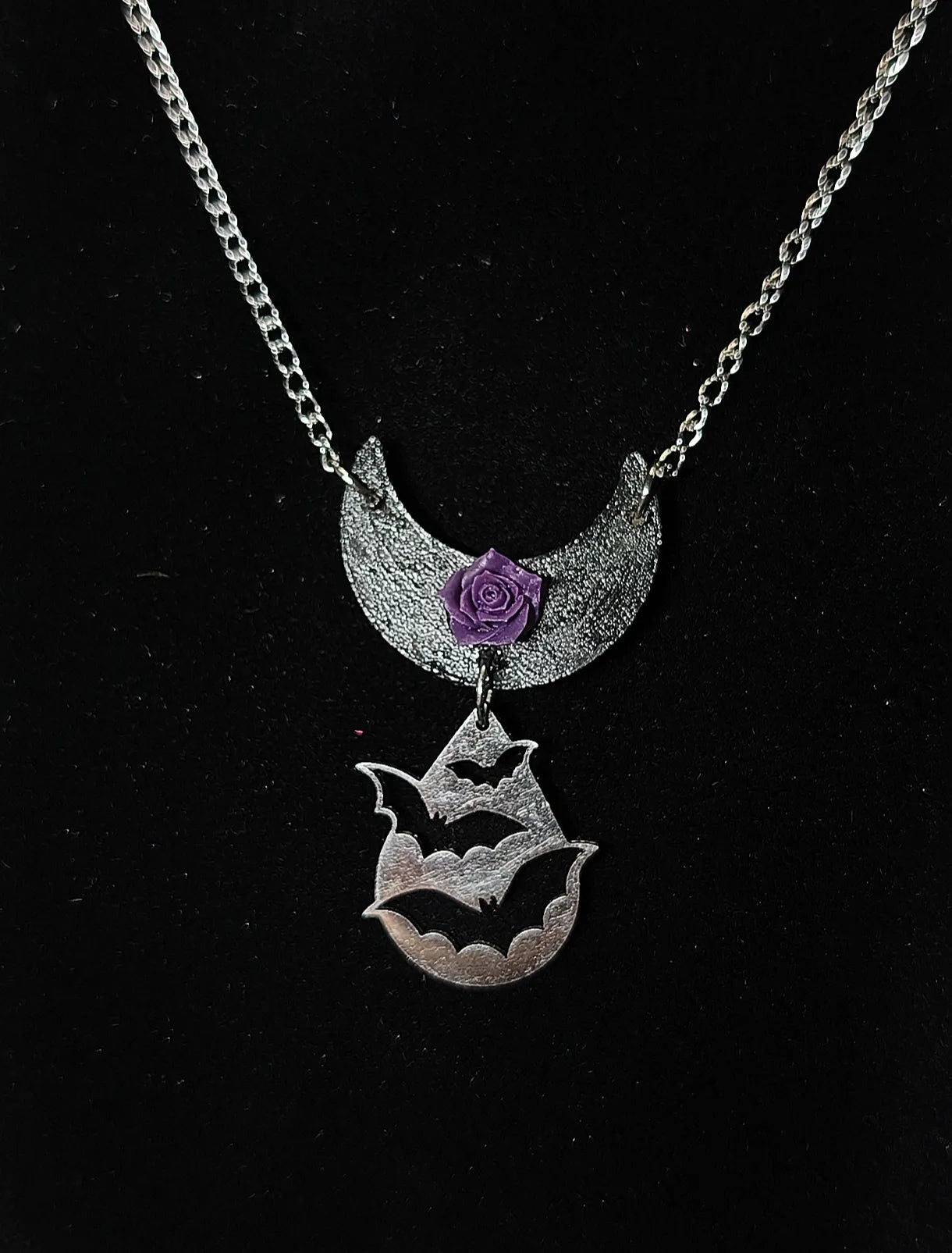 Gros plan collier gothique lune en bois noir rose violette en résine et pendentif chauves-souris