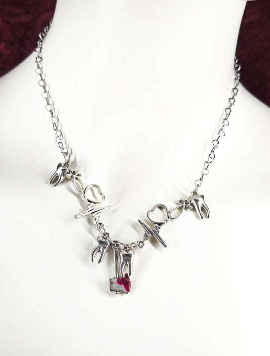 Collier avec hache, électrocardiogramme et dent en référence à la chanson Stupid de la chanteuse Ashnikko