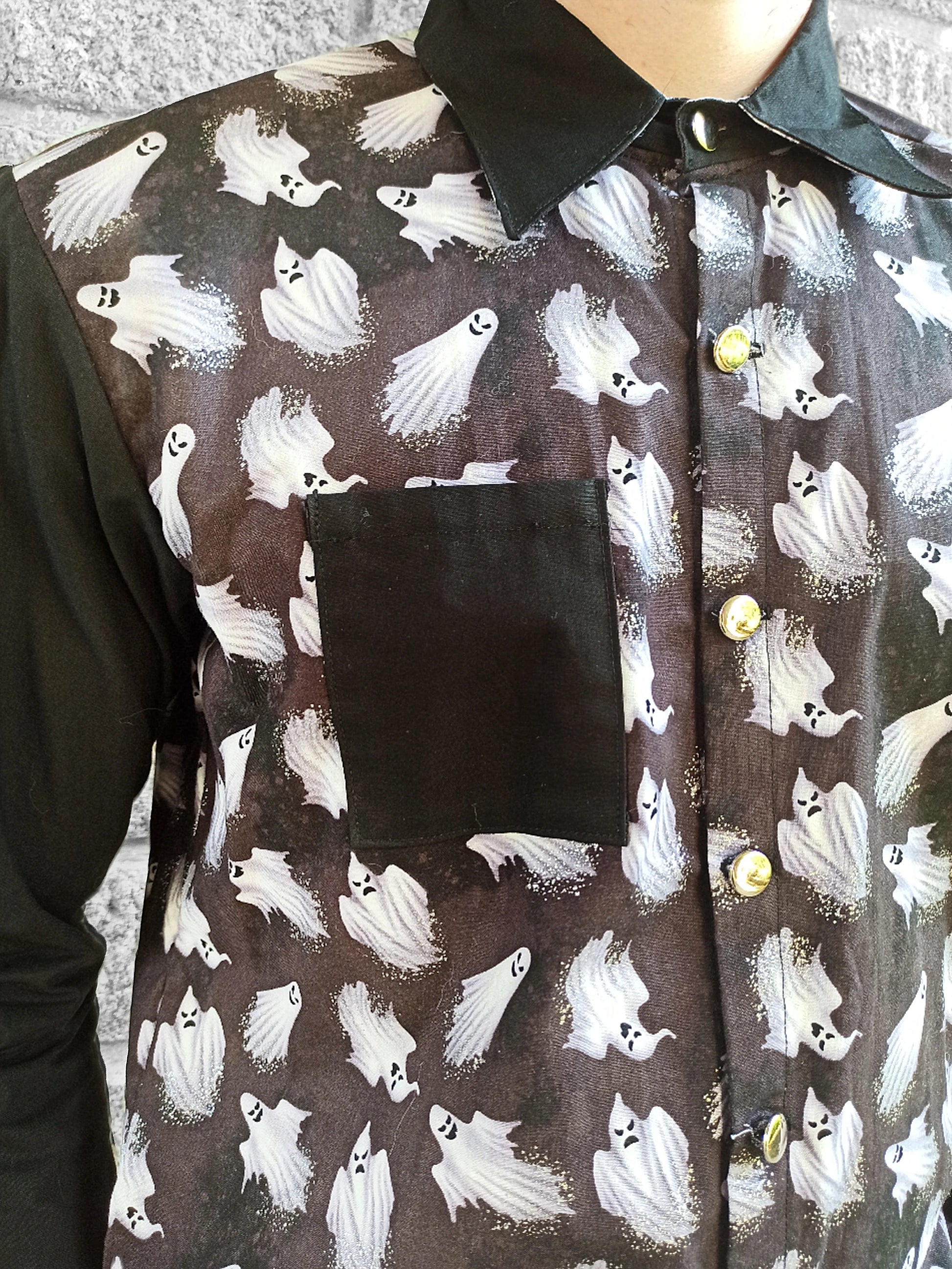 Boutons argentés sur chemise noire alternative
Zoom sur les paillettes fantômes et contraste tissu noir
