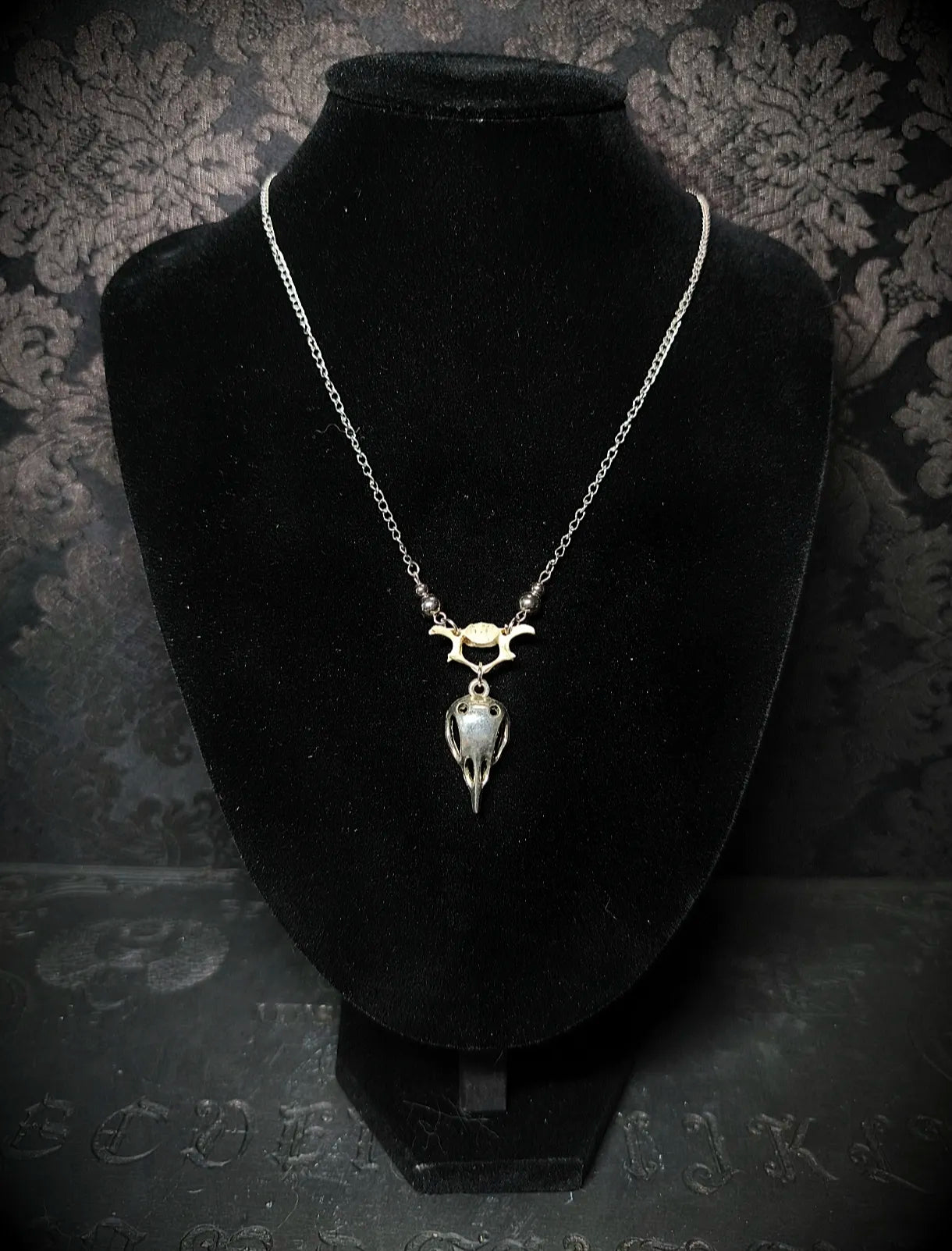 Collier gothique Ossuaire avec véritable vertèbre animale et pendentif crâne en acier inoxydable sur buste noir