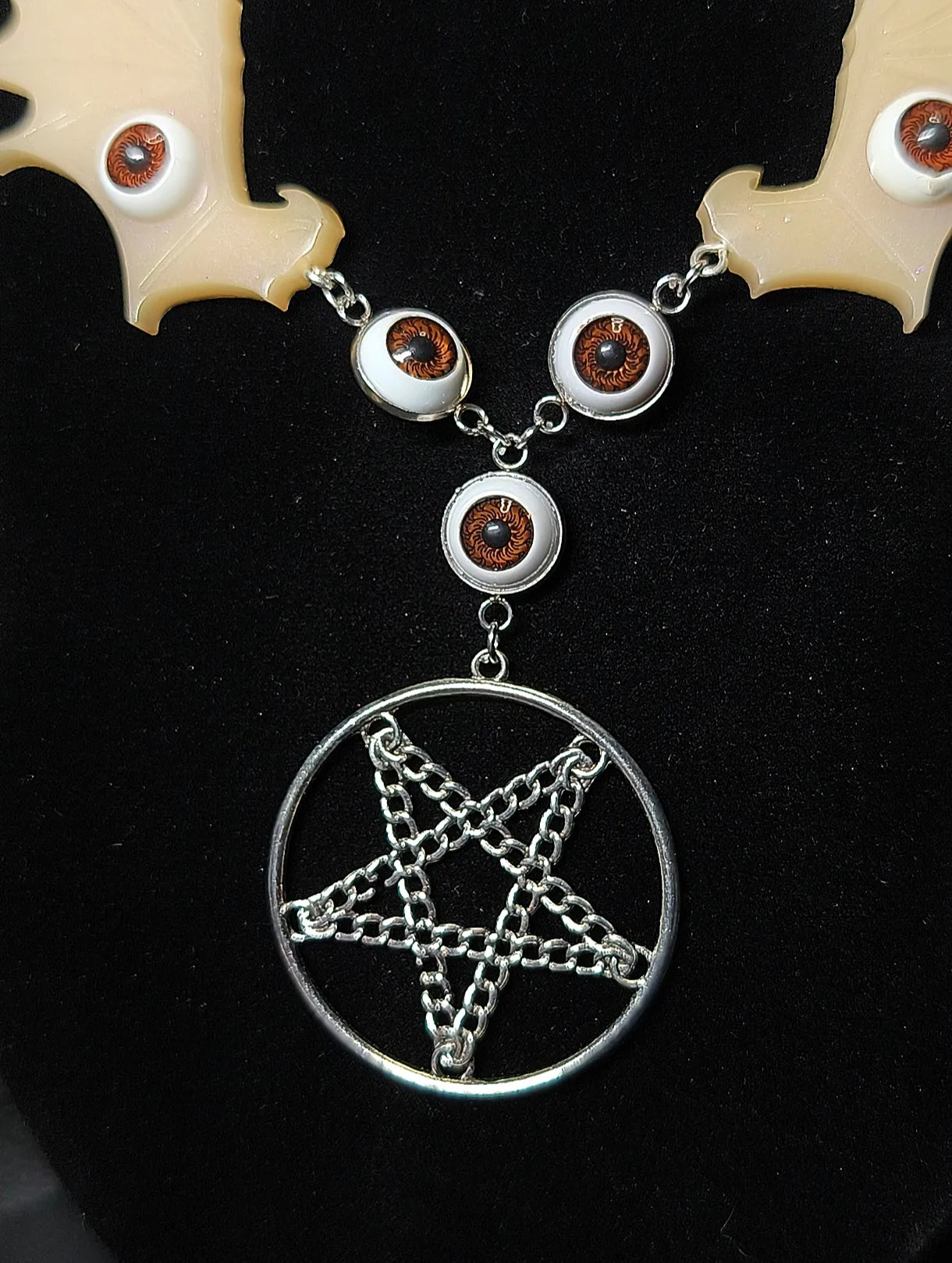 Détail collier gothique yeux brun orange et pentagramme argenté en chaînes