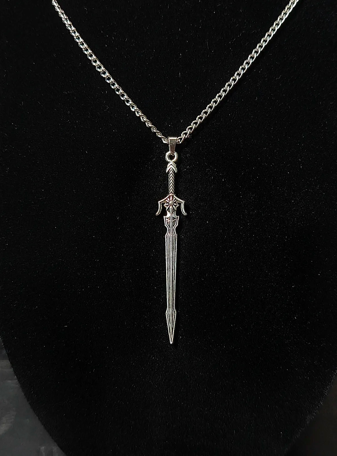 Détail de l'épée du collier épée dans la parure