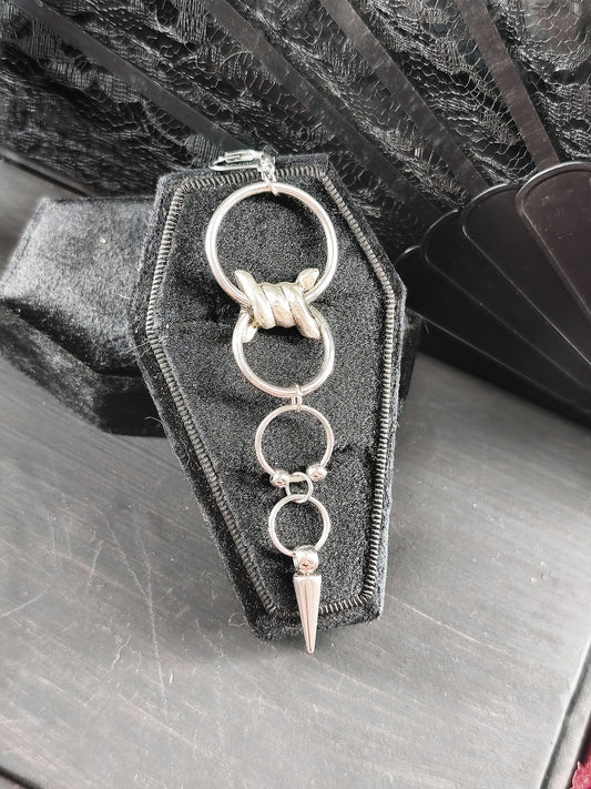Détail de la boucle d’oreille unique barbelé et anneaux en acier inoxydable fait main