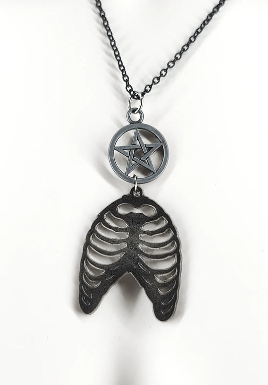 Détail du collier gothique noir en résine avec cage thoracique et pentacle
