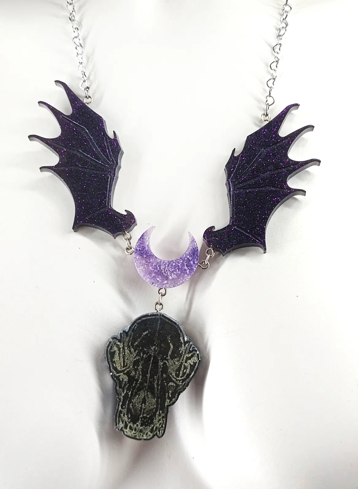 Détail du collier pastel goth en résine avec lune, ailes et crâne de loup