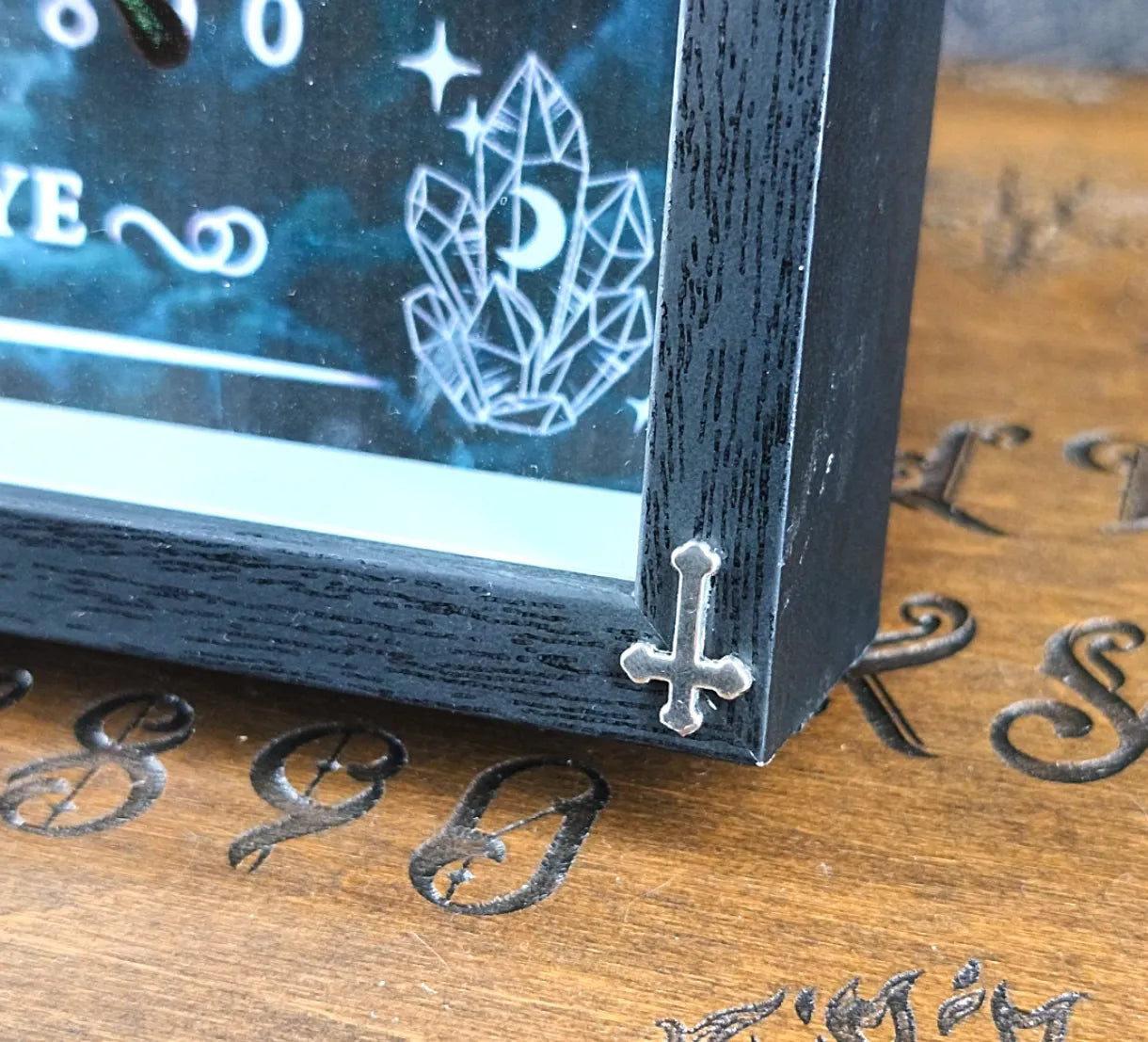 Détail de la croix sur le bas du cadre gothique 