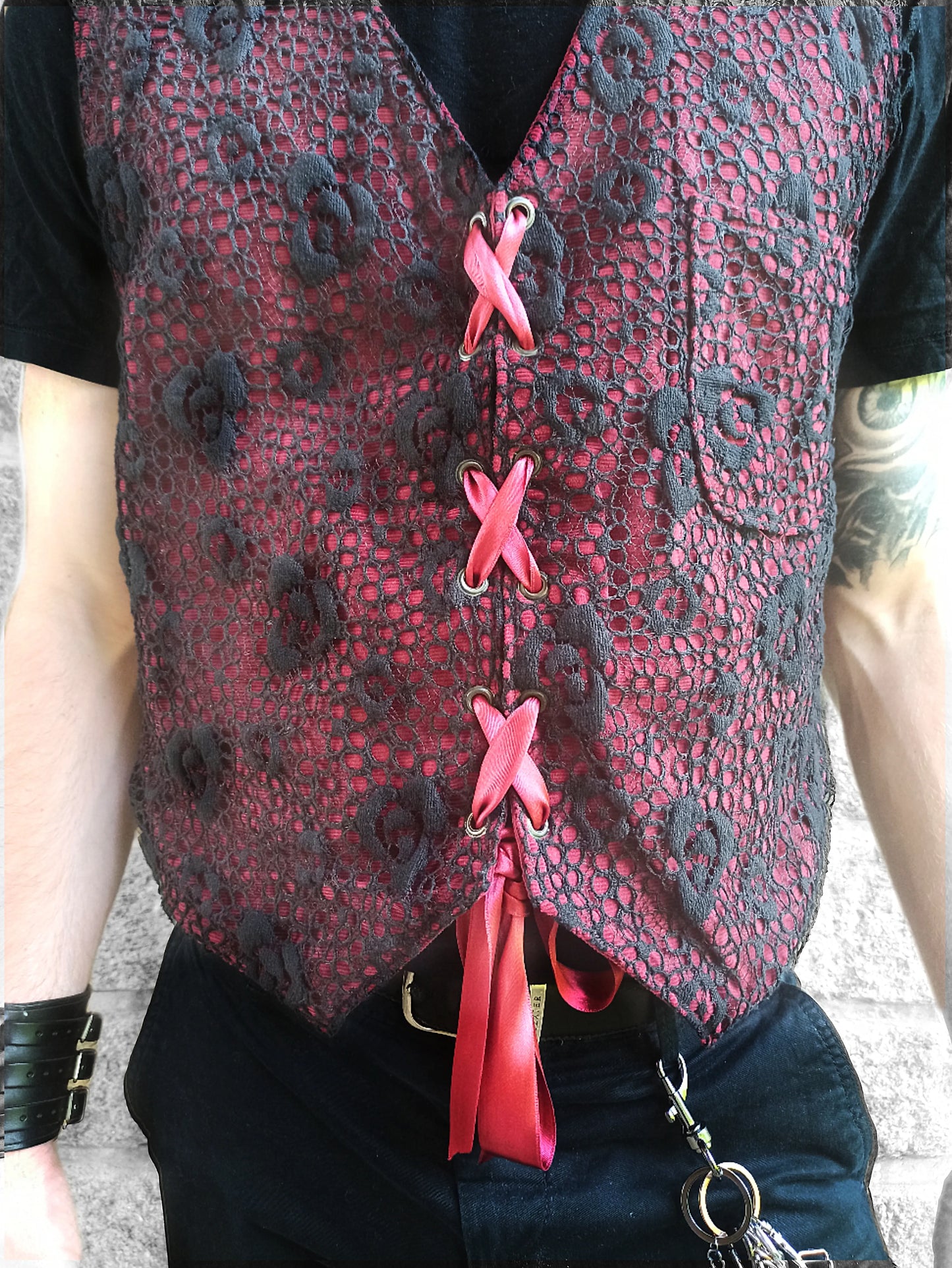 Vue de face du gilet style gothique romantique
Tissu en velours côtelé bordeaux avec texture visible
Finitions en dentelle noire sur gilet gothique raffiné
Détail de la fermeture à ruban satin bordeaux et œillets métal