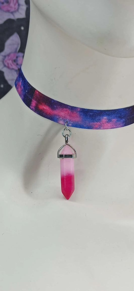 Gros plan sur pendentif en verre rose-violet en forme de cristal – bijou style cosmique et féérique