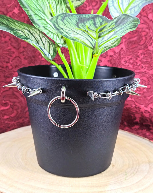 Cache-pot décoratif avec anneaux, clous et chaînes vu de près