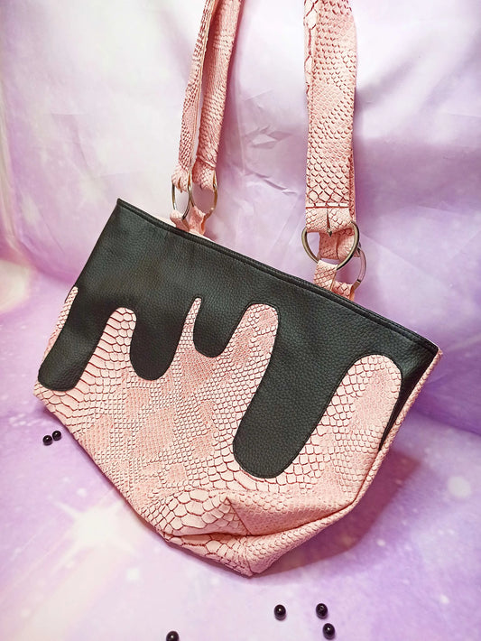 Sac à main pastel goth en simili cuir rose avec coulures noires
Détail de cœur décoratif sur anses de sac fait main
Intérieur coton rose pastel avec poches décoratives
Sac gothique rose effet serpent avec finitions artisanales
Pastel goth handbag in pink faux leather with black drips
Handmade purse with heart-shaped handle details
Pastel pink cotton lining with faux leather pockets
Gothic pink snake-textured bag with custom finishings