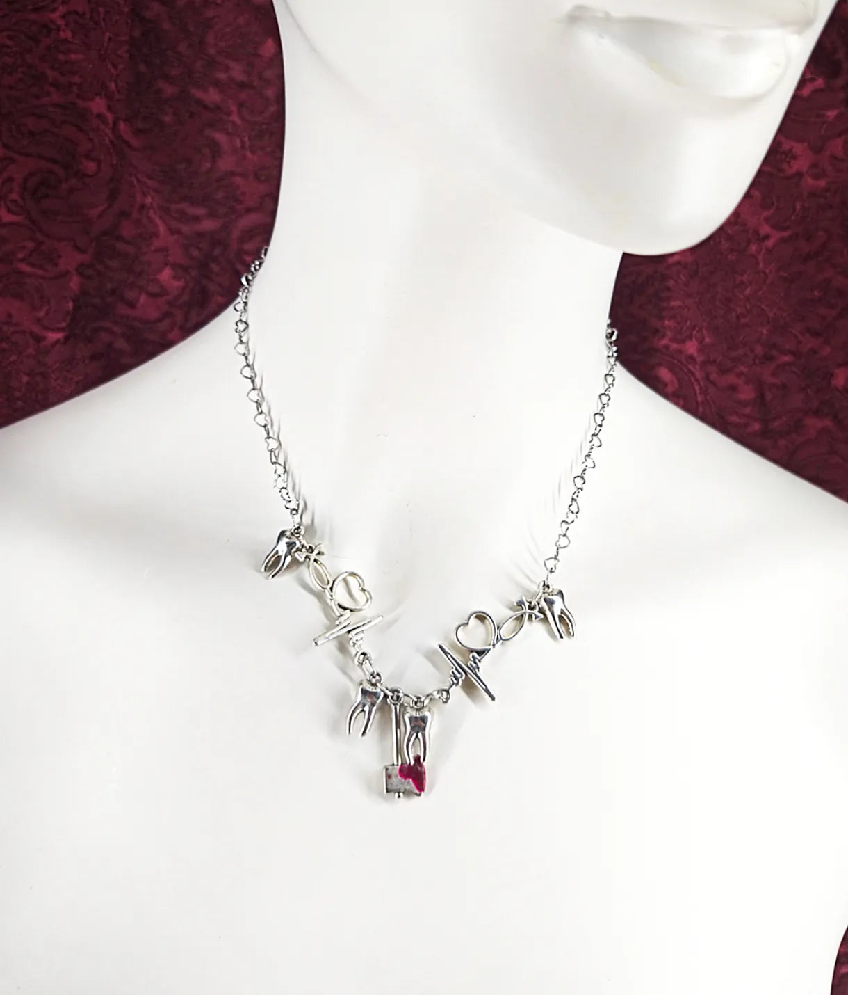 Collier avec hache, électrocardiogramme et dent en référence à la chanson Stupid de la chanteuse Ashnikko