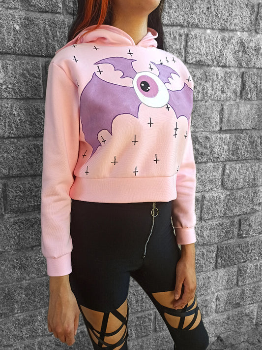 Sweat-shirt court rose pastel goth à capuche, en jersey de coton doux, avec œil démoniaque peint à la main. Pièce unique, artisanale et confortable.
