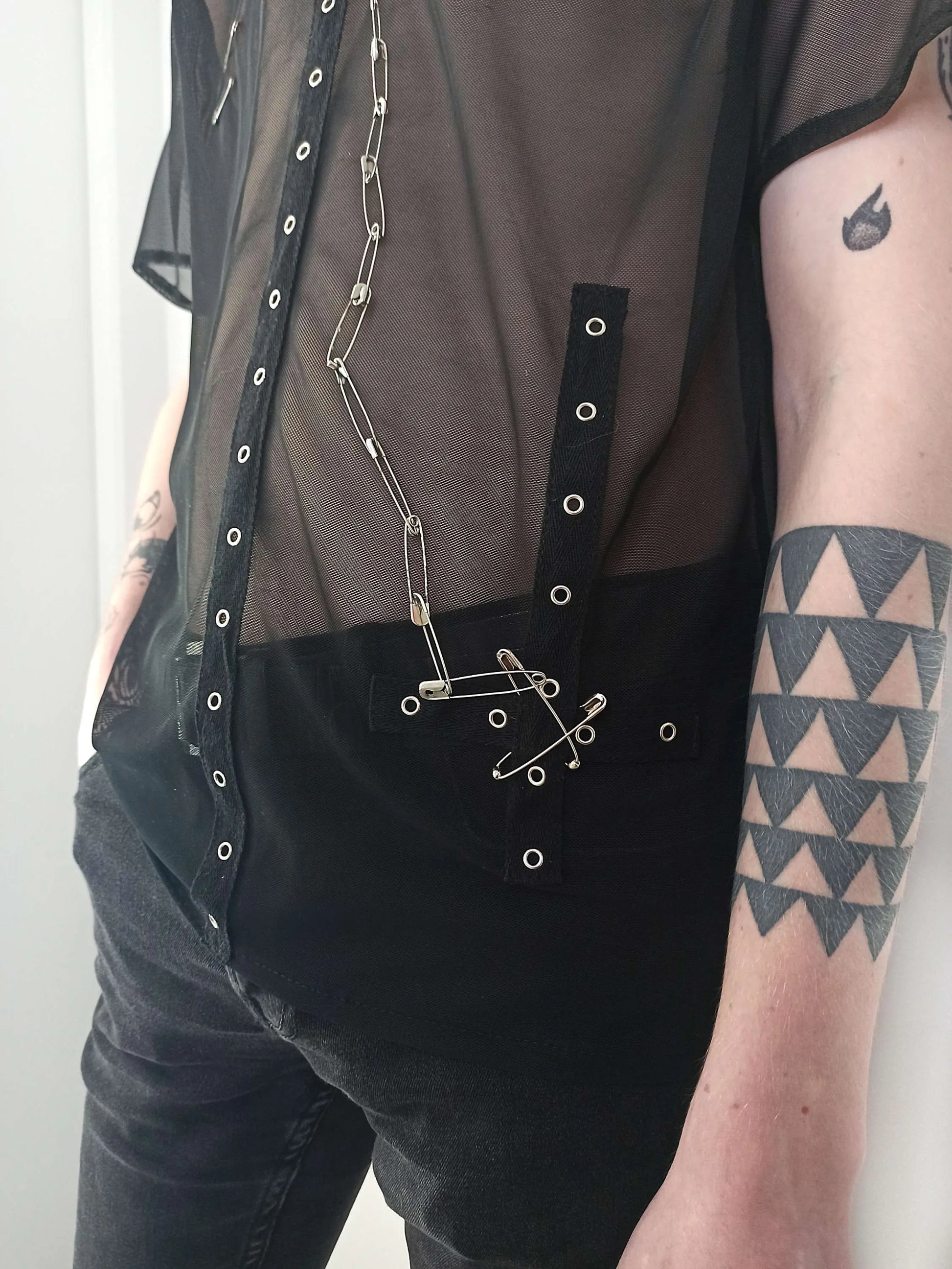 Détail de la bande coton en forme de croix avec chaîne à épingles