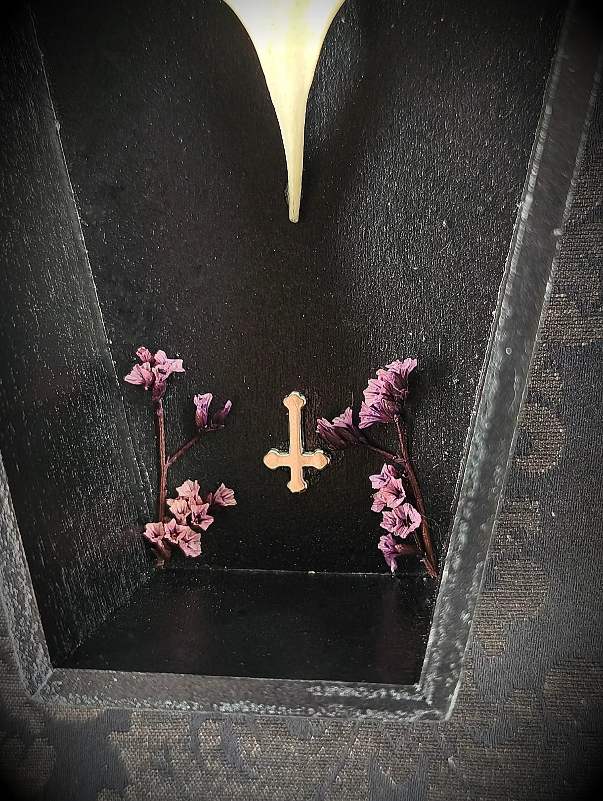 Vue de la croix et des fleurs séchées violettes du cadre cercueil 