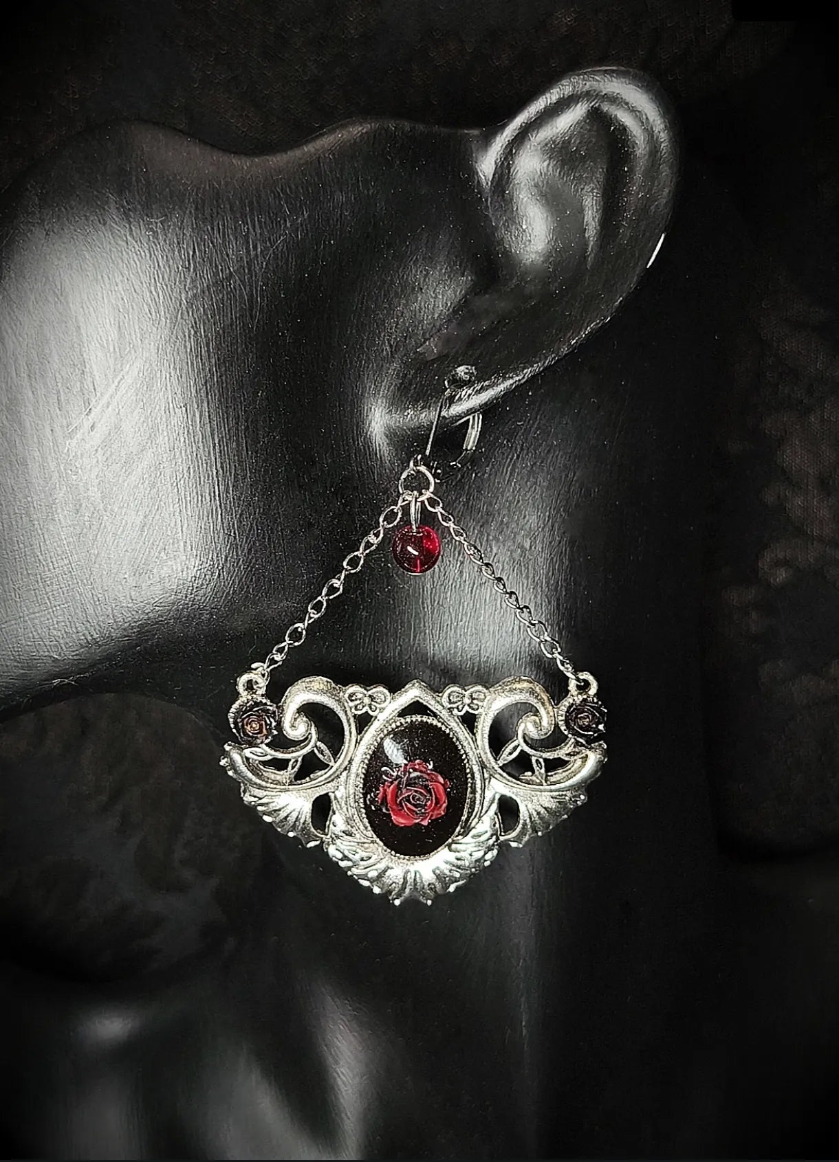 Vue rapprochée de la boucle d’oreille gothique avec médaillon rose rouge, perle de verre et chaînes argentées