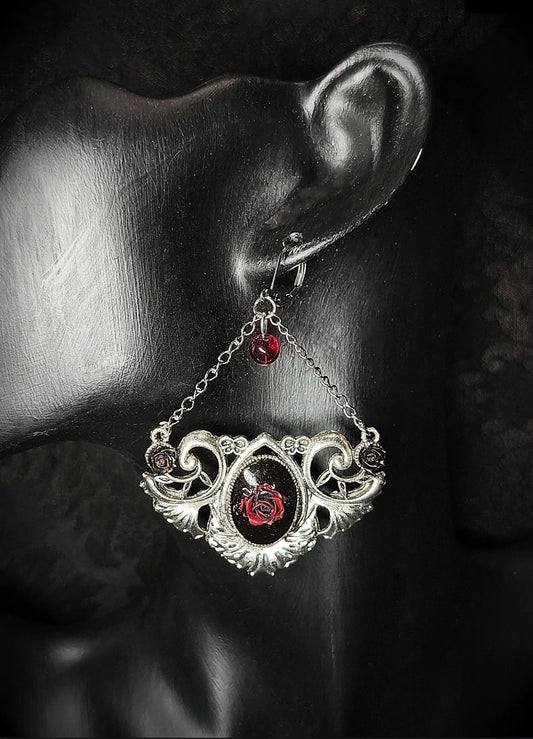 Vue rapprochée de la boucle d’oreille gothique avec médaillon rose rouge, perle de verre et chaînes argentées